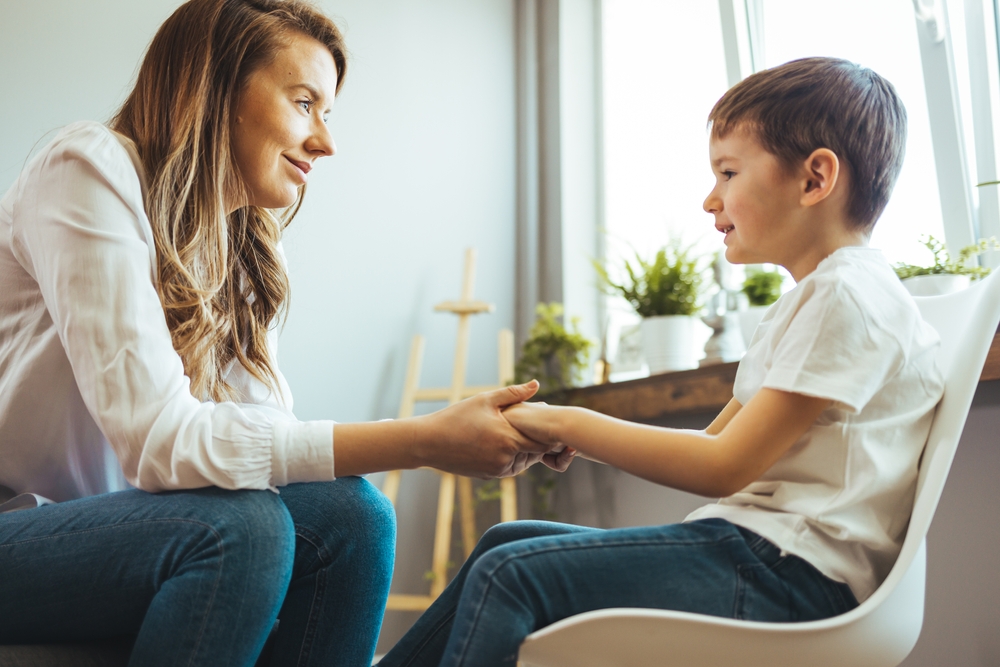 Young,boy,having,therapy,with,a,child,psychologist.,smiling,woman